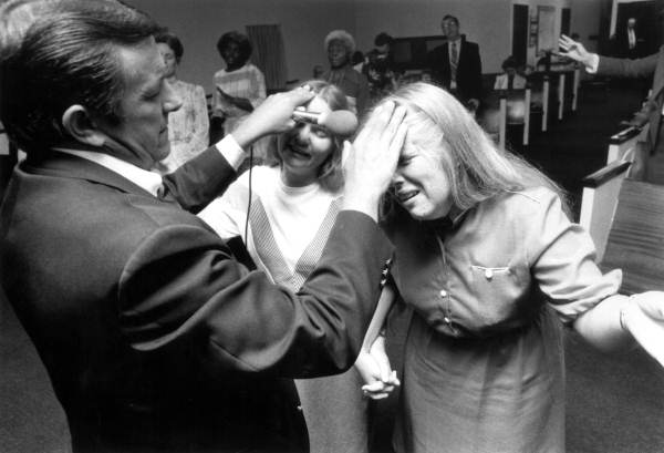 Man lays is hands on two women in an act of healing at a Pentecostal revival - Tallahassee, 1985